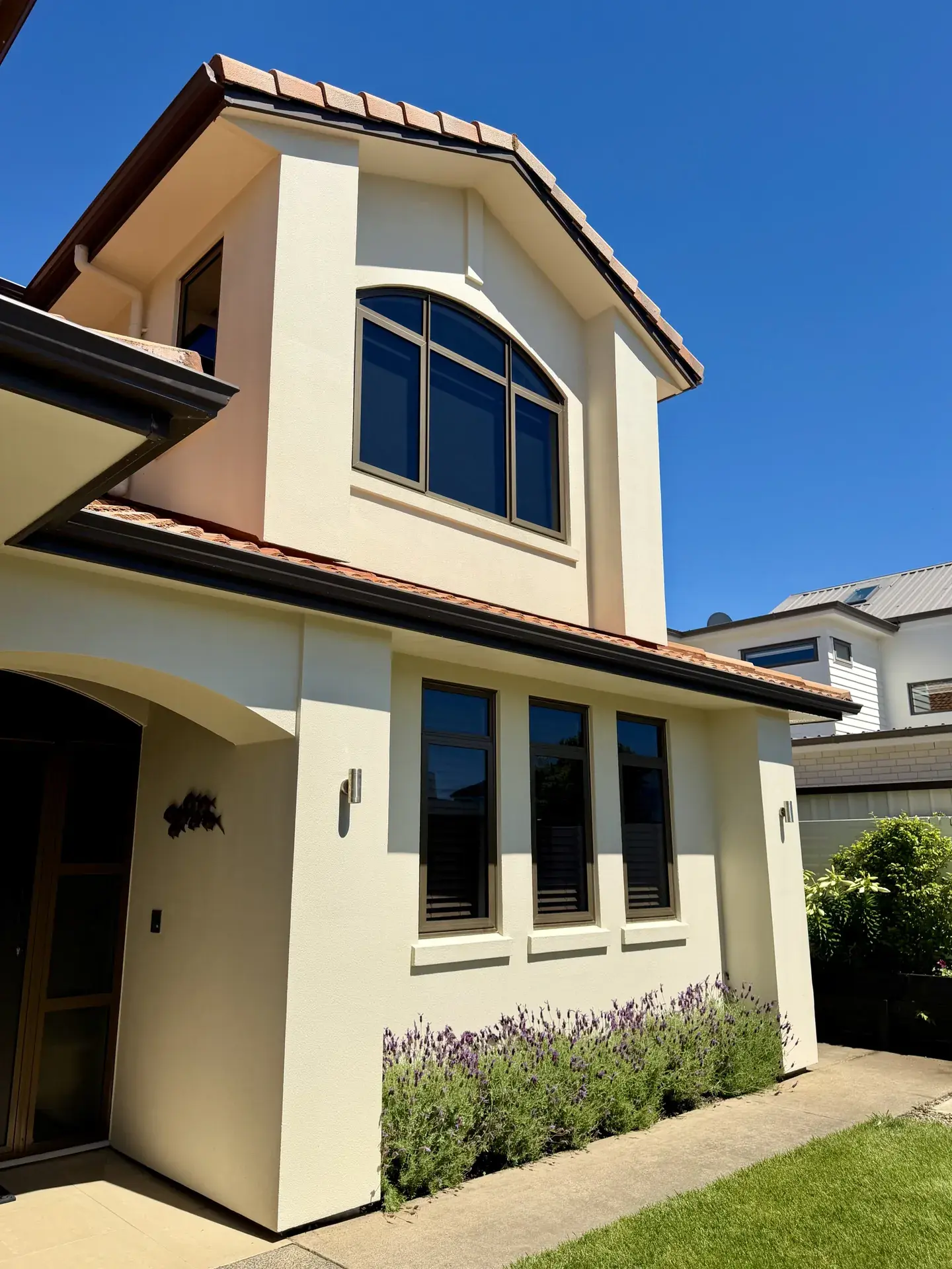 Professional house washing in Auckland — Essential Water Blasting soft wash technician cleaning a home exterior